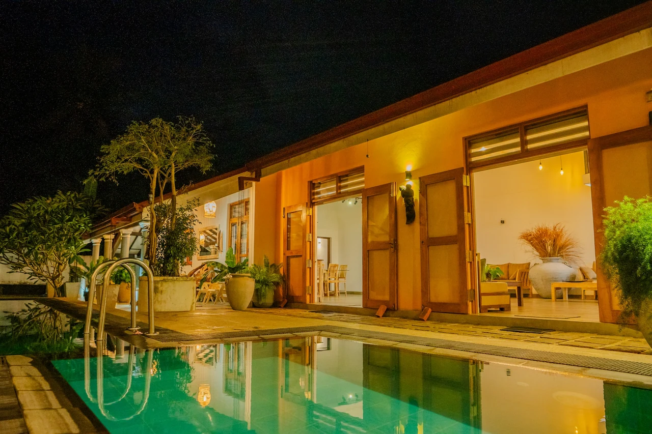 A warmly illuminated villa overlooking a tranquil pool